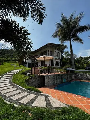 a house with a swimming pool in front of a house at Apto nuevo y moderno con piscina y bbq, zona rural in Anserma