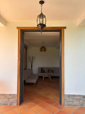 an open door into a living room with a couch at Apto nuevo y moderno con piscina y bbq, zona rural in Anserma