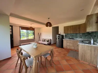 a kitchen with a table and chairs in a room at Apto nuevo y moderno con piscina y bbq, zona rural in Anserma