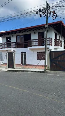 a white house with wooden balconies on a street at Hotel San Joaquin Jerico in Jericó