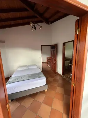 a bedroom with a bed and a mirror at Hotel San Joaquin Jerico in Jericó