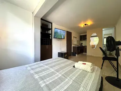 a bedroom with a large bed and a television at Apartaestudio en Laureles-plaza mayor-Av 33-laundry-wifi in Medellín