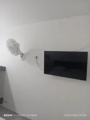 a light attached to a wall with a television at Hotel eden centro in Medellín