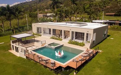 an aerial view of a house with a swimming pool at Villa with Pool, Jacuzzi, and Nature in Medellín