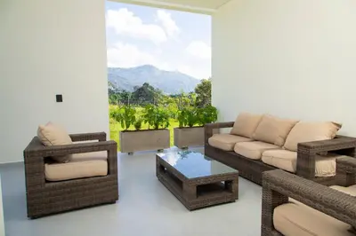 a living room with a couch and chairs and a table at Villa with Pool, Jacuzzi, and Nature in Medellín