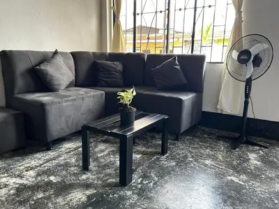 a living room with a couch and a table with a fan at Casa Hotel Milagro de Abril in Mutatá