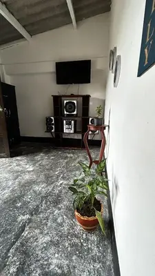 a room with a tv and a plant on a table at Casa Hotel Milagro de Abril in Mutatá
