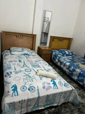a bedroom with two beds and a bedspread with bicycles on it at Casa Hotel Milagro de Abril in Mutatá