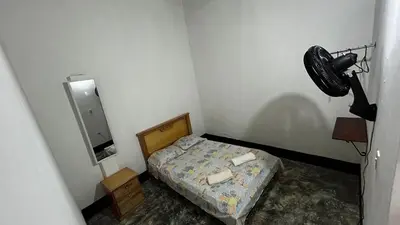 a small bedroom with a bed and a fan at Casa Hotel Milagro de Abril in Mutatá