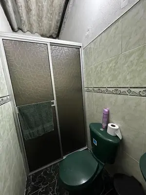a bathroom with a green toilet and a shower at Casa Hotel Milagro de Abril in Mutatá