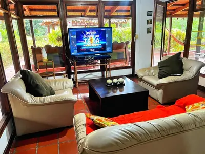 a living room with couches and a flat screen tv at La Cornalina in Santa Fe de Antioquia