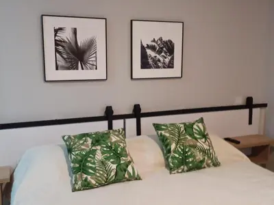 a bedroom with a bed with two pictures on the wall at Vibra en el corazón de Medellin! in Medellín