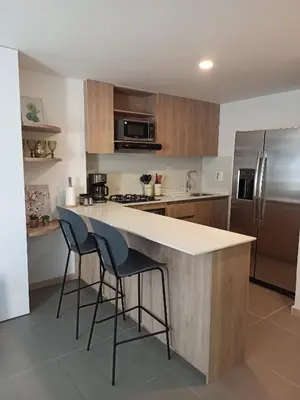 a kitchen with a counter and two bar stools at Vibra en el corazón de Medellin! in Medellín