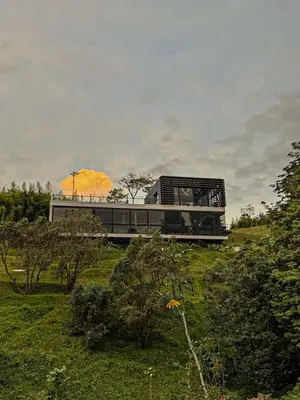 a house sitting on top of a green hill at Luxury Country Suite in Retiro, Antioquia in El Retiro