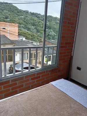 a room with a large window with a view at Ninfa del Mar Hostal Turístico in Manizales
