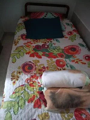 a bed with a blanket with flowers on it at Ninfa del Mar Hostal Turístico in Manizales
