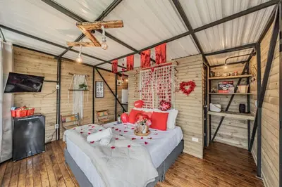 a bedroom with a bed with red pillows at Glamping con vista de lujo in Guatapé