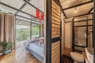 a bedroom in a tiny house with a bed and a balcony at Glamping con vista de lujo in Guatapé