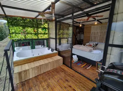 a large bathroom with a tub and a bedroom at Glamping con vista de lujo in Guatapé
