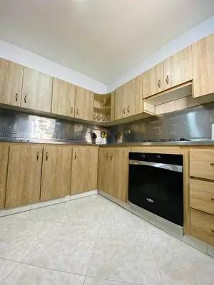 a kitchen with wooden cabinets and a black dishwasher at Apartamento comodo, 3 Hab, cerca Poblado in Medellín