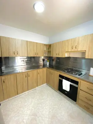 a kitchen with wooden cabinets and a stove top oven at Apartamento comodo, 3 Hab, cerca Poblado in Medellín