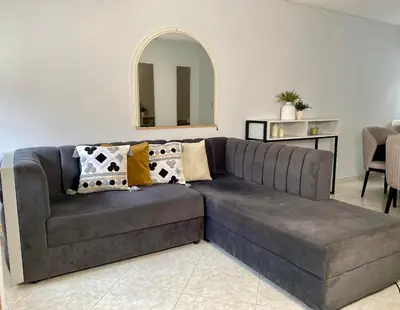 a grey couch in a living room with a mirror at Apartamento comodo, 3 Hab, cerca Poblado in Medellín