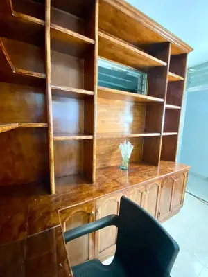 a wooden book shelf with a desk and a chair at Apartamento comodo, 3 Hab, cerca Poblado in Medellín