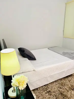 a bedroom with a bed with a yellow lamp and flowers at Apartamento comodo, 3 Hab, cerca Poblado in Medellín