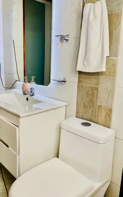 a bathroom with a toilet and a sink and a mirror at Apartamento comodo, 3 Hab, cerca Poblado in Medellín