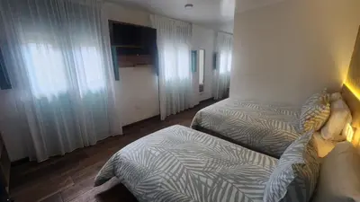 a hotel room with two beds and a window at Hotel Boutique Paraíso Plaza Aguadas in Aguadas
