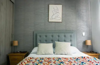 a bed with a blue headboard in a bedroom at 804- APTO 3BR a Pasos del Parque de Sabaneta in Sabaneta