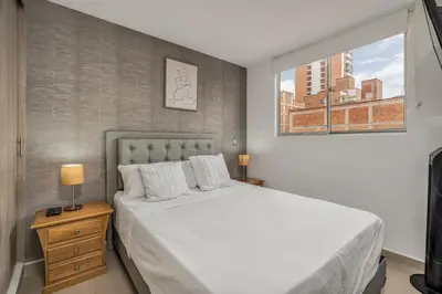a bedroom with a large white bed and a window at 804- APTO 3BR a Pasos del Parque de Sabaneta in Sabaneta