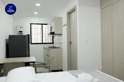 a room with a kitchen and a bed and a table at Luzor Apartments in Medellín