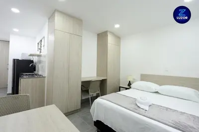 a hotel room with a bed and a desk at Luzor Apartments in Medellín