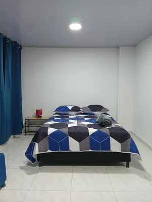 a bedroom with a bed in a white room at Nápoles city in Medellín
