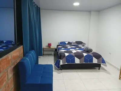 a bedroom with a bed and a blue couch at Nápoles city in Medellín