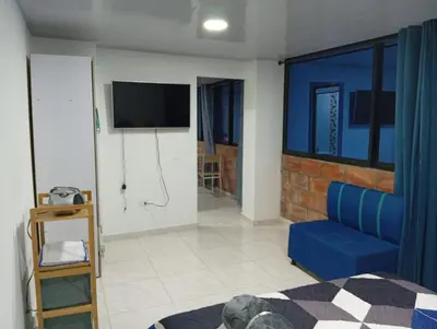a living room with a blue couch and a tv at Nápoles city in Medellín