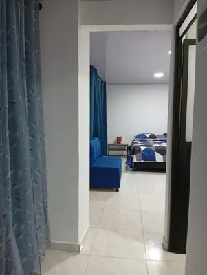 a bedroom with a blue couch and a bed at Nápoles city in Medellín