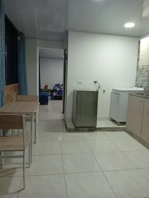 a room with a kitchen with a table and a counter at Nápoles city in Medellín