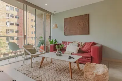 a living room with a red couch and a table at Luxury Studio El Poblado Pool Rooftop 4th Floor in Medellín