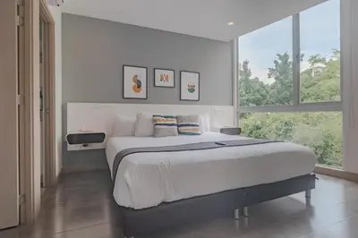 a bedroom with a large bed and a large window at Luxury Studio El Poblado Pool Rooftop 4th Floor in Medellín
