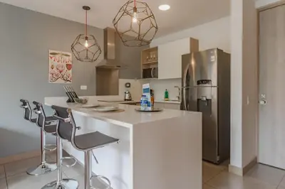 a kitchen with a white counter and a refrigerator at Luxury Studio El Poblado Pool Rooftop 4th Floor in Medellín