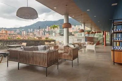a restaurant with chairs and tables and a view of a city at Luxury Studio El Poblado Pool Rooftop 4th Floor in Medellín