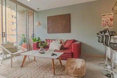 a living room with a red couch and a table at Luxury Studio El Poblado Pool Rooftop 4th Floor in Medellín