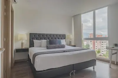 a bedroom with a large bed with a large window at Luxury Studio El Poblado City View 7th Floor in Medellín