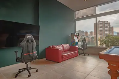 a living room with a red chair and a pool table at Luxury Studio El Poblado City View 7th Floor in Medellín