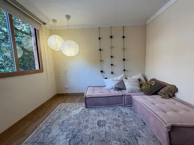 a living room with a couch and a large window at Arroyuelos in Estación El Salto