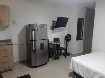 a kitchen with a refrigerator and a table in it at Amoblados la 70 Medellin 1 in Medellín