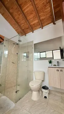 a bathroom with a toilet and a glass shower at Private room Laureles, Estadio, la 70 Fast WIFI in Medellín