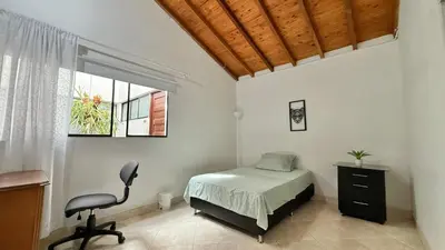 a bedroom with a bed and a chair and a window at Private room Laureles, Estadio, la 70 Fast WIFI in Medellín